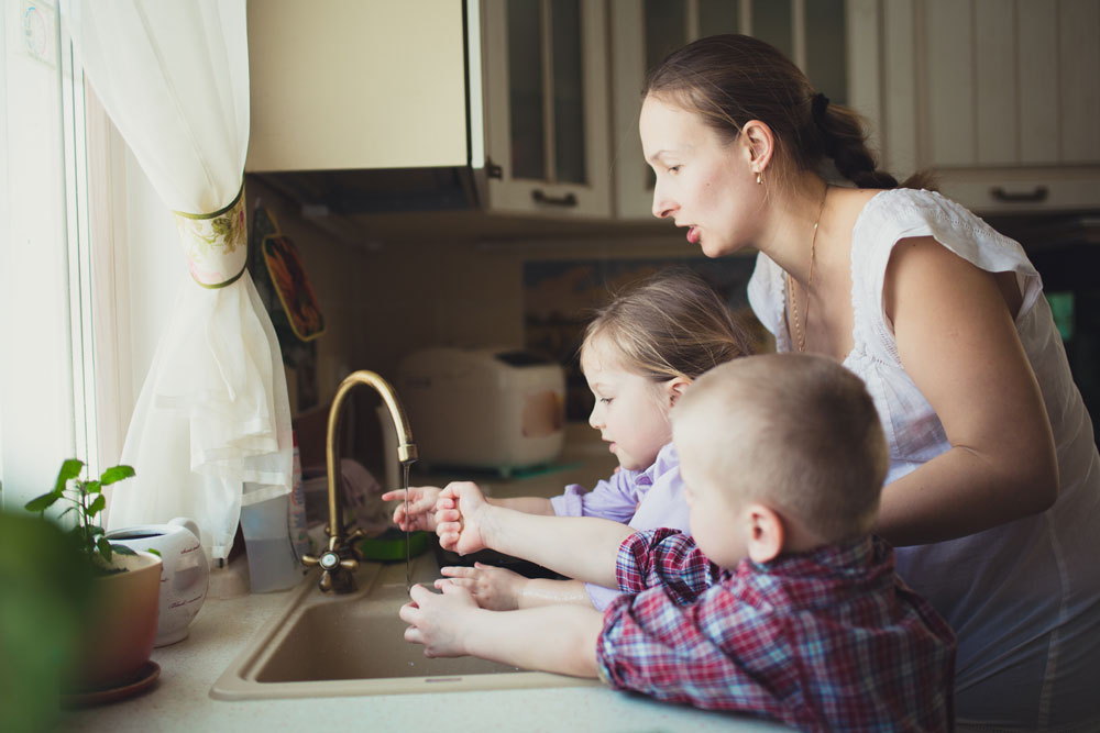 family at sink with water on